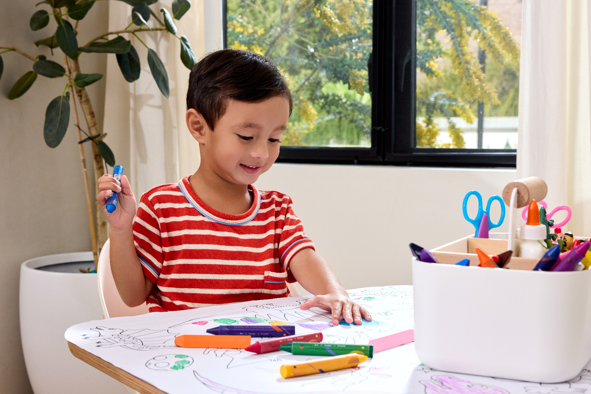 Child coloring at a Lalo Play Table with crayons and Play Caddy